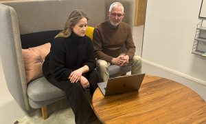 Tarkin toimitusjohtaja Olivia Järvinen ja Melba Digitalin toimitusjohtaja Jukka Järvinen istumassa sohvalla tietokoneen äärellä.